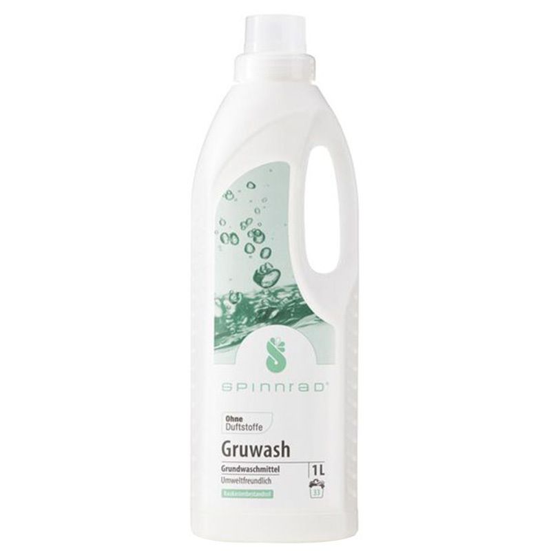 Bouteille blanche avec poignée, Spinnrad Gruwash Grundwaschmittel flüssig. 1L. Sans parfum. Étiquette verte et blanche avec informations.