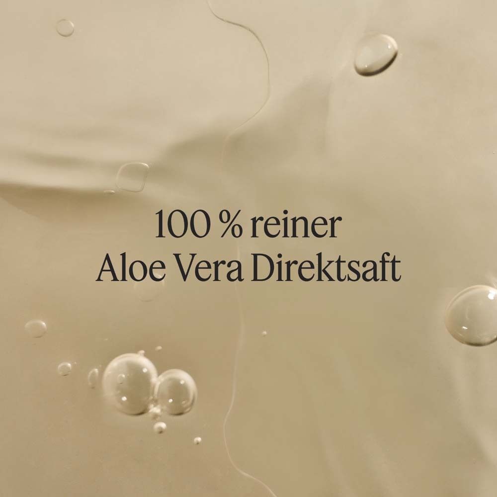 Gros plan sur un liquide avec des bulles. Texte: 100 % pur jus d'aloe vera.