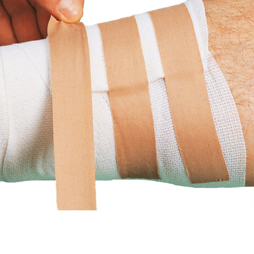 Ruban adhésif de couleur chair sur un bandage. Une main retire un pansement.