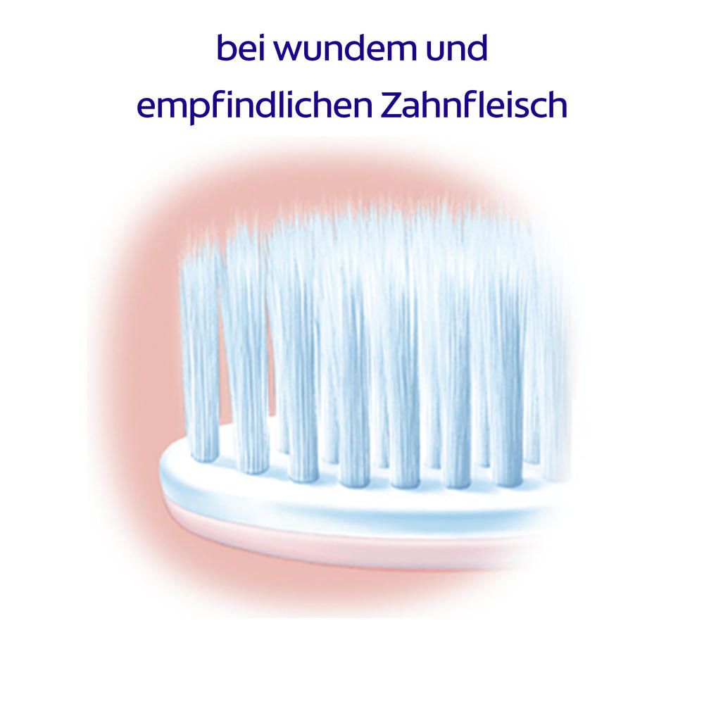 Gros plan des poils d'une brosse à dents. Texte : "pour les gencives sensibles".