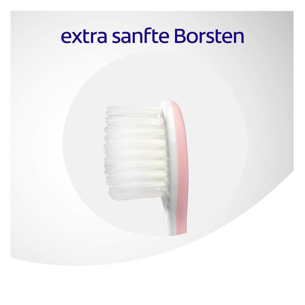 Gros plan de la tête d'une brosse à dents. Texte : "soies extra douces".