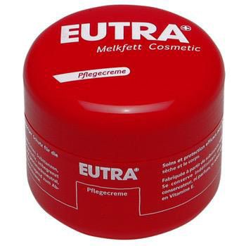 Pot rouge avec texte blanc: EUTRA Melkfett Cosmetic Pflegecreme. Couvercle avec texte. Pot cylindrique.