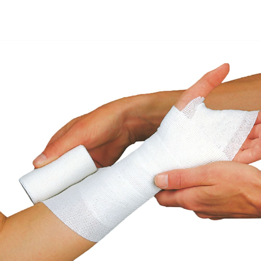 Un bandage blanc est appliqué sur un bras. Un rouleau est à côté. Des mains tiennent le bras.