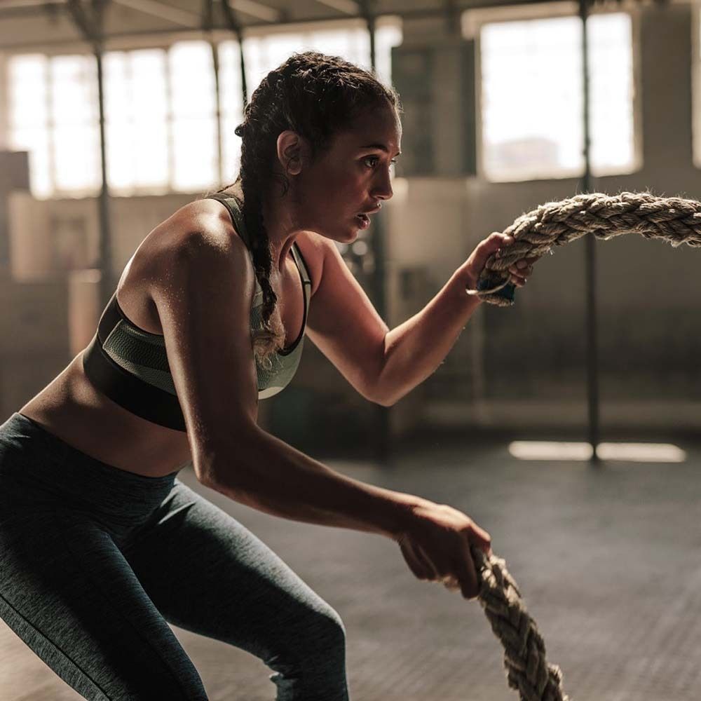 Femme tirant une corde dans une salle de sport. Vêtements de sport, tenant une corde.