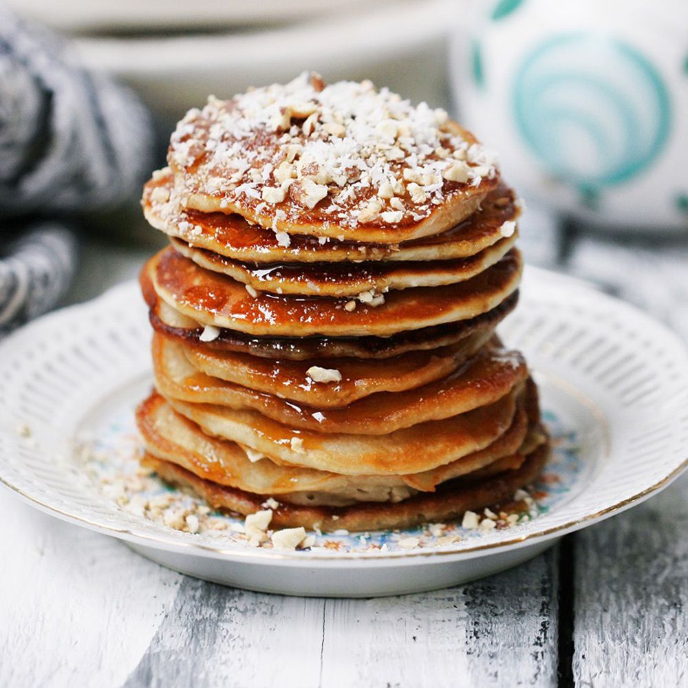 Pile de crêpes avec liquide brun et noix. Sur une assiette.