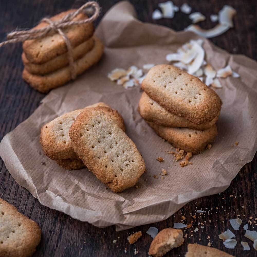 Plusieurs biscuits sur papier sulfurisé, liés avec une ficelle. Fond en bois.
