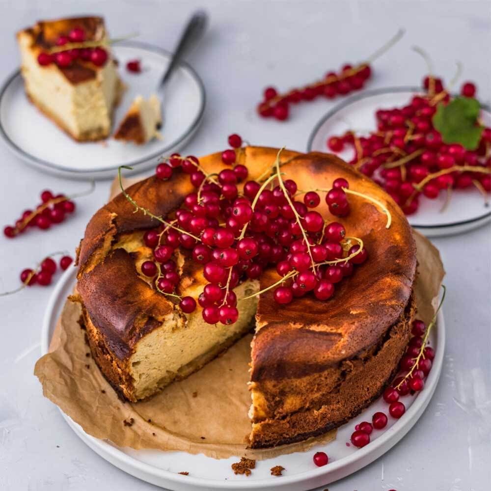 Cheesecake avec groseilles rouges. Sur une assiette, avec d'autres assiettes de baies.