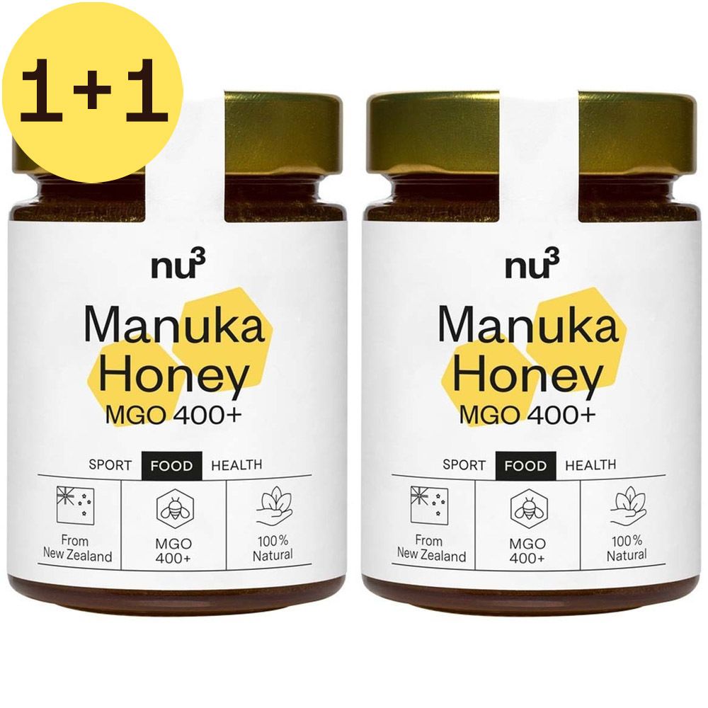 Deux pots de miel "Manuka Honey MGO 400+" avec autocollant "1+1". Couvercles dorés, étiquettes blanches.