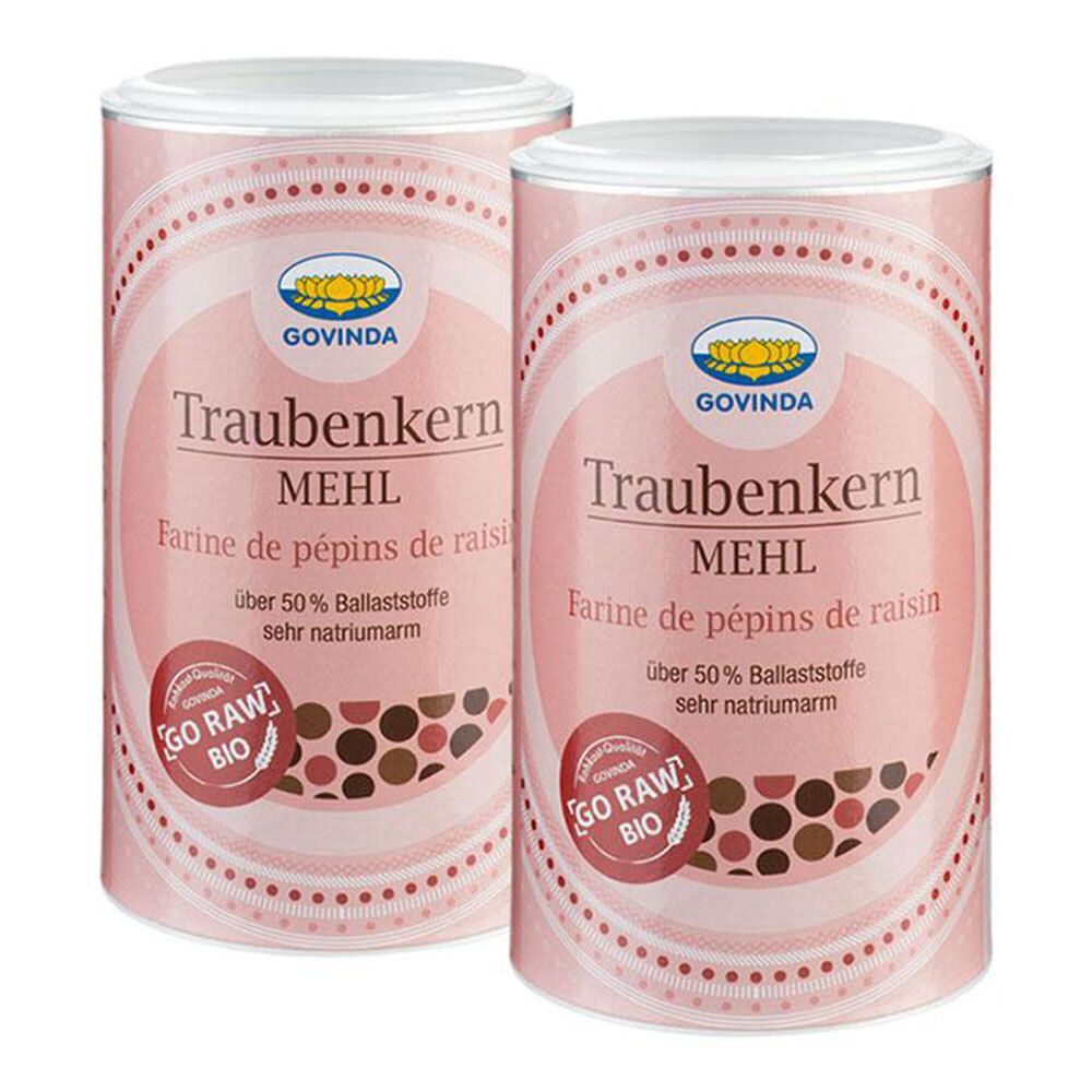 Deux boîtes cylindriques avec couvercles blancs. Inscription : Govinda Traubenkern Mehl, Farine de pépins de raisin. Avec label bio.
