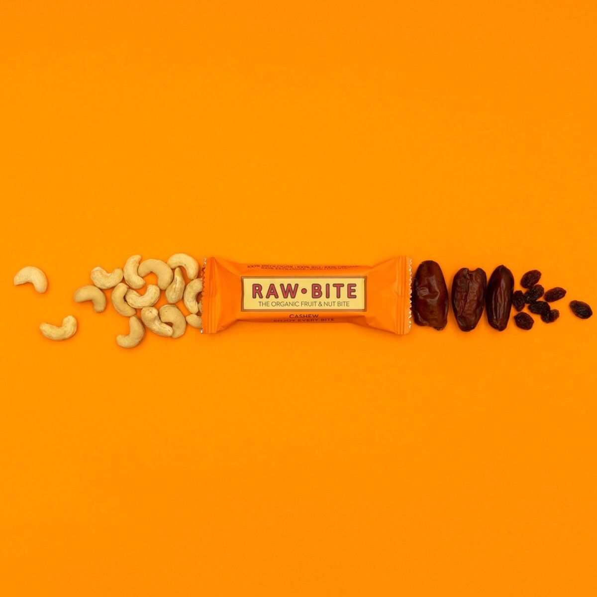 Une barre avec des noix de cajou et des dattes sur fond orange. Inscription : RAWBITE, THE ORGANIC FRUIT & NUT BITE, Cashew.