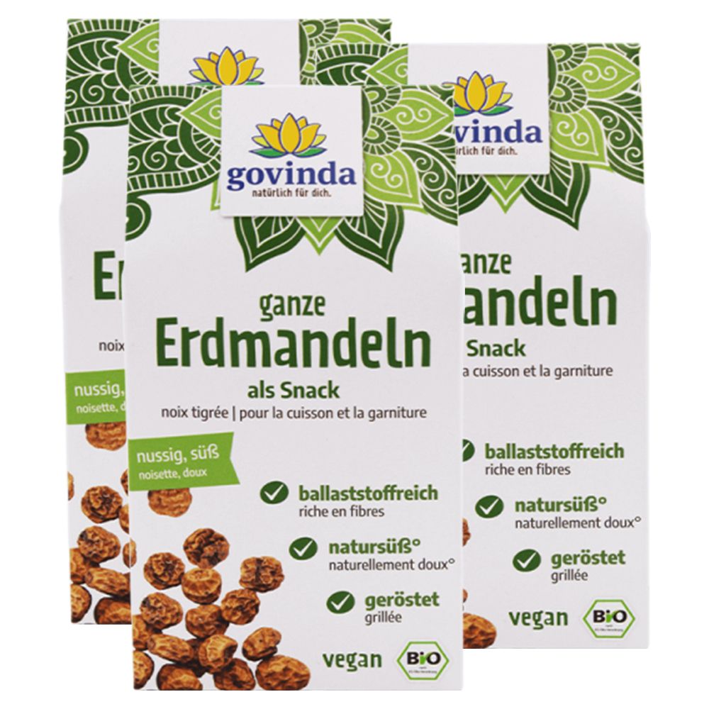 Trois paquets de "Govinda ganze Erdmandeln". Emballage blanc avec éléments verts et informations produit. Label bio.
