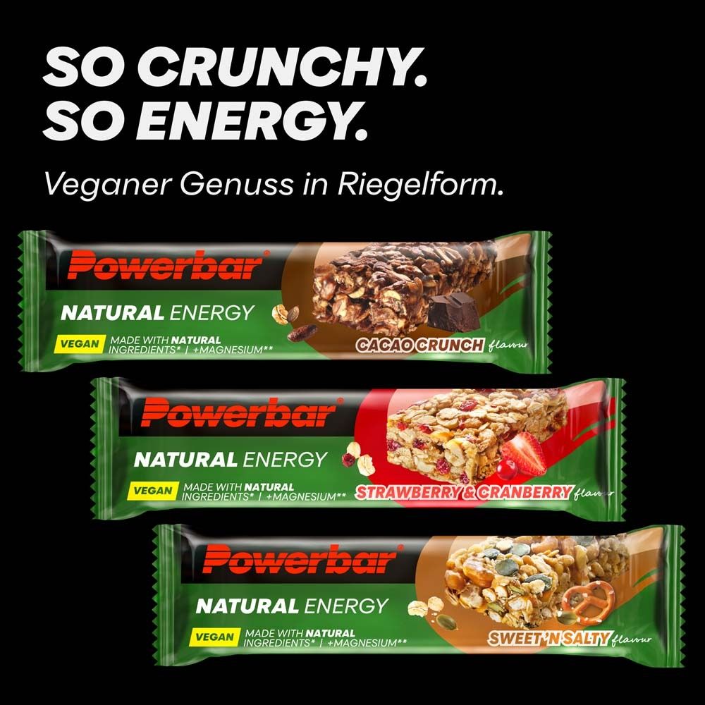 Trois barres PowerBar Natural Energy. Fraise-canneberge, Cacao Crunch, Sweet 'n Salty. Fond noir. Vegan.