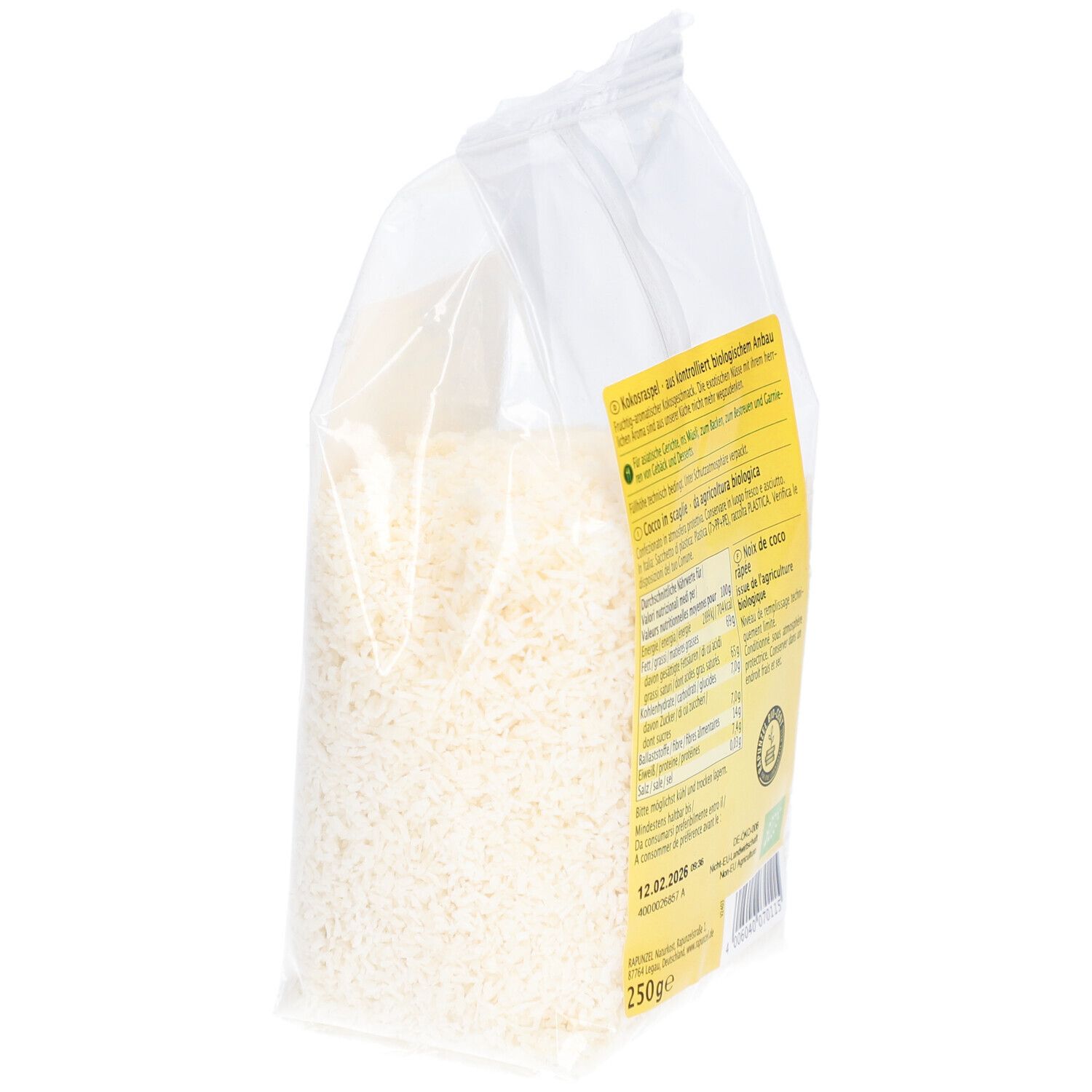 Dos d'un sachet transparent de copeaux de noix de coco. Étiquette avec informations sur le produit. Vue en biais.