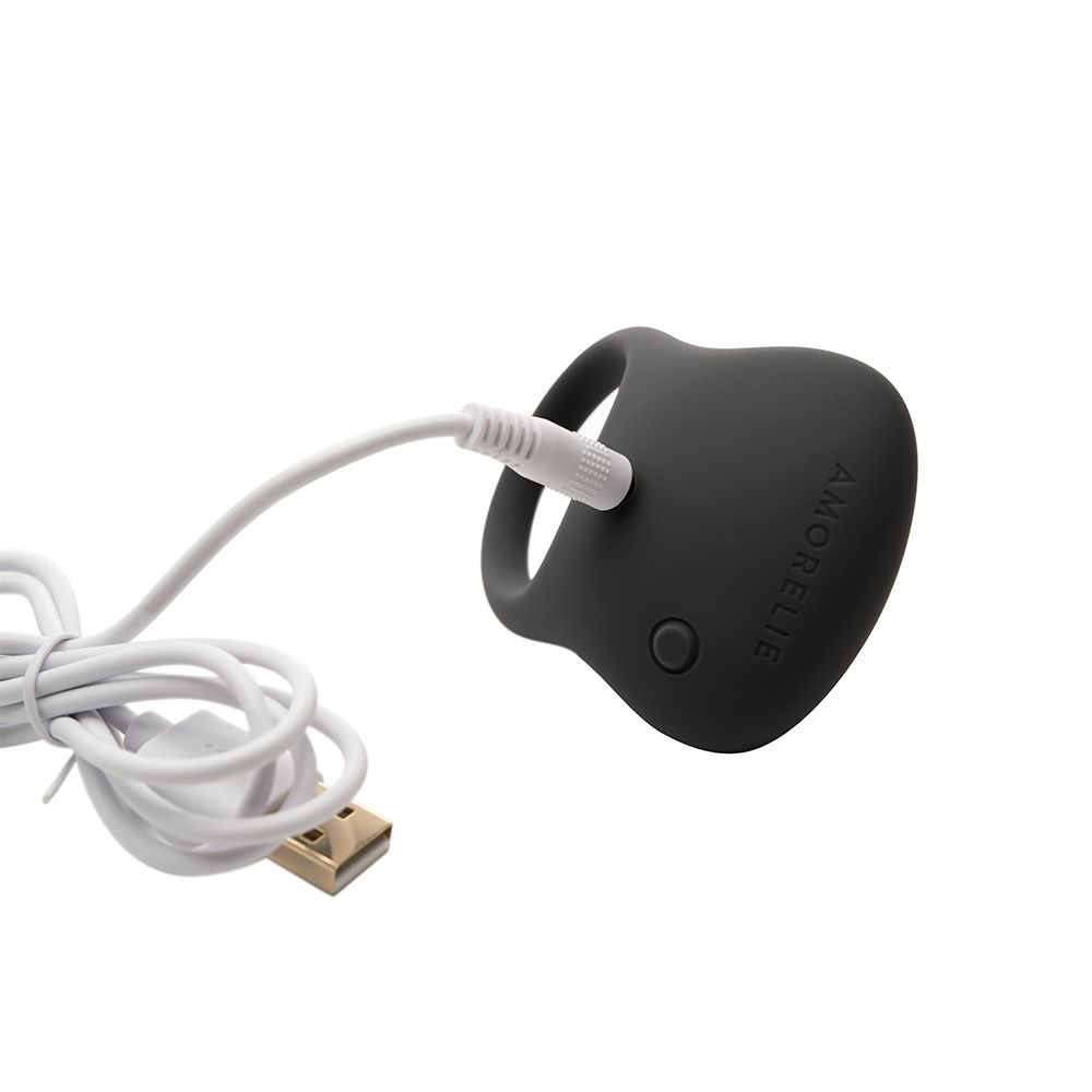 Anneau pénien gris avec câble USB. Boutons visibles. Logo AMORELIE.