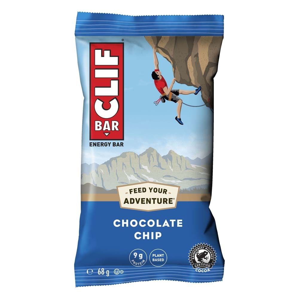 Emballage de barre énergétique CLIF Bar®. Fond bleu, grimpeur, montagnes. Inscription: Chocolate Chip, 9g protéines, cacao certifié.
