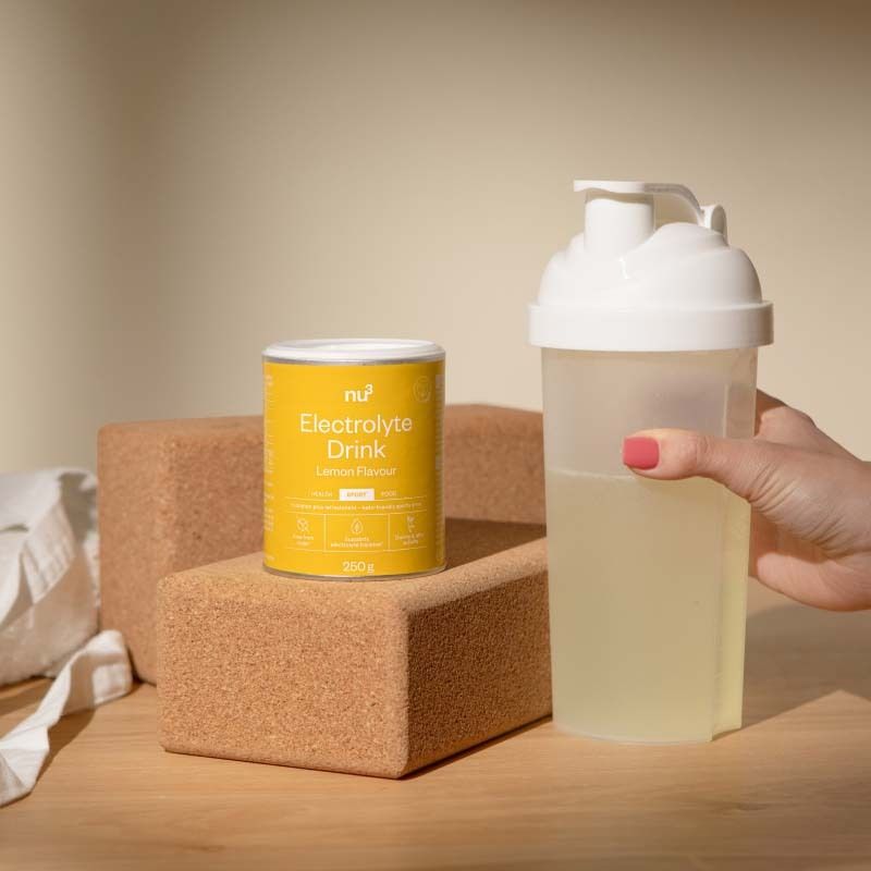 Boîte Nu3 Elektrolyte Drink à côté d'un shaker avec boisson.