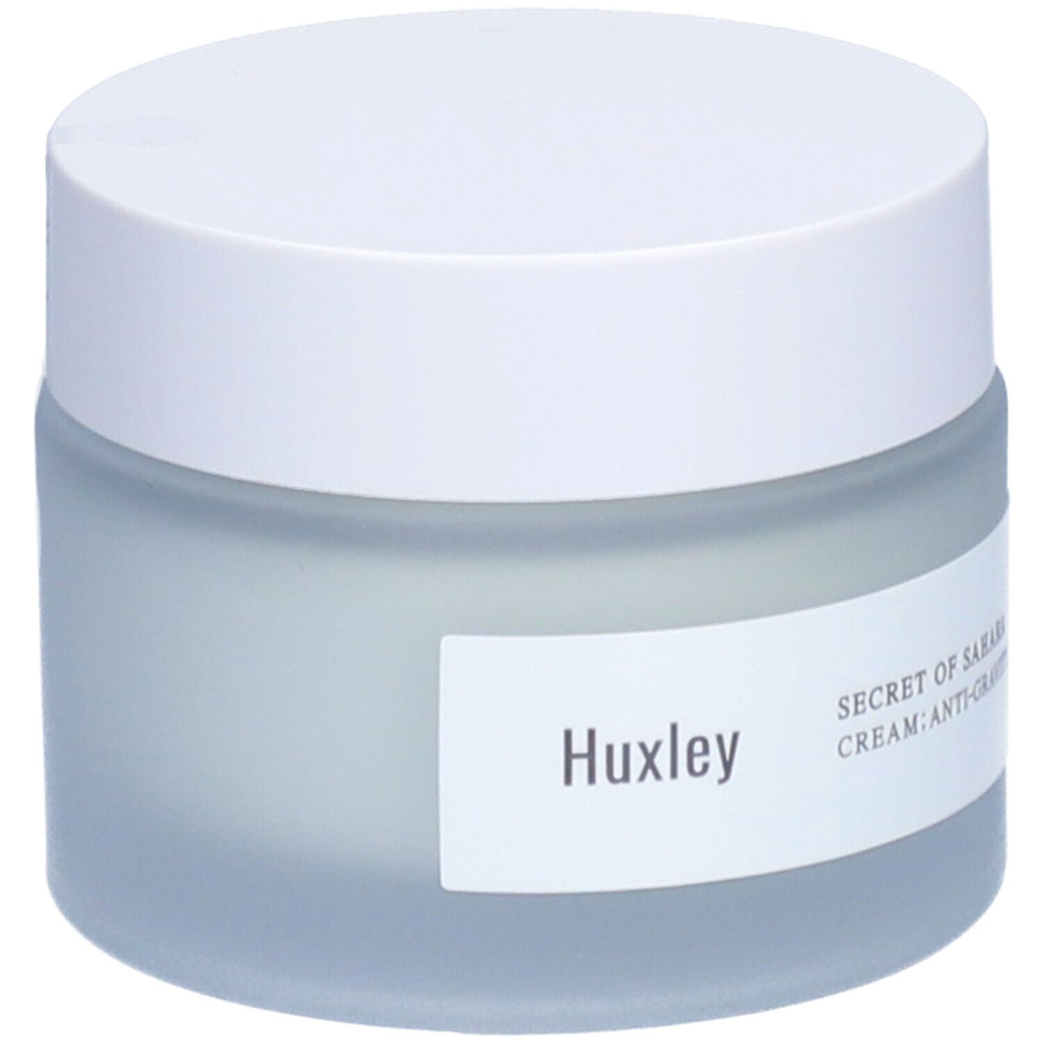 Pot de crème avec couvercle blanc. Étiquette avec 'Huxley' et 'Secret of Sahara Cream: Anti-Gravity'.