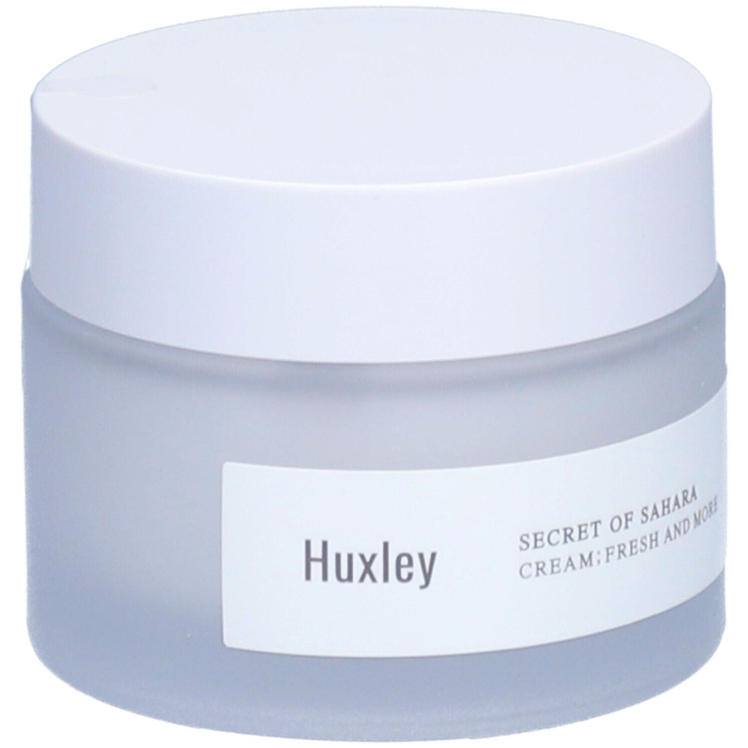 Pot de crème avec couvercle blanc. L'étiquette indique Huxley et Secret of Sahara Cream Fresh And More.