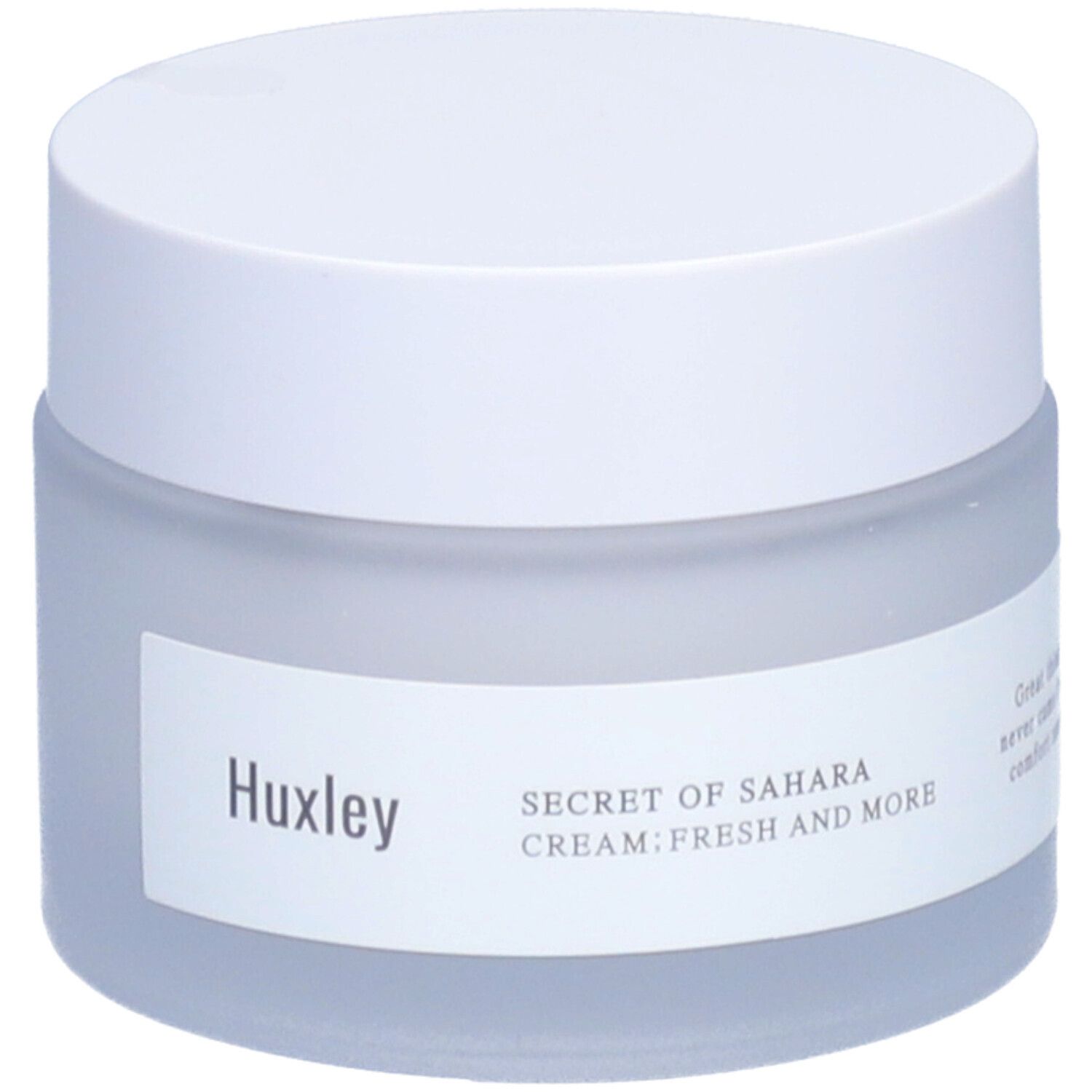 Pot de crème avec couvercle blanc. L'étiquette indique Huxley et Secret of Sahara Cream Fresh And More.