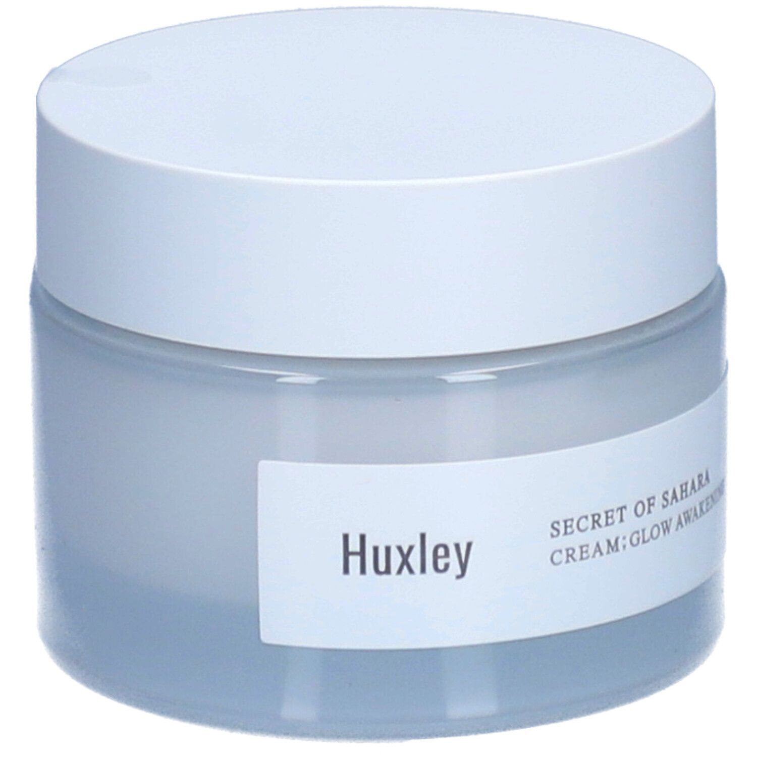Pot de crème avec couvercle blanc. Étiquette "Huxley" et "SECRET OF SAHARA CREAM; GLOW AWAKENING".