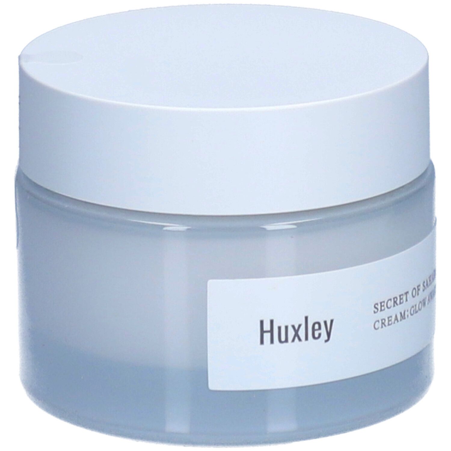 Pot de crème avec couvercle blanc. Étiquette "Huxley" et "SECRET OF SAHARA CREAM; GLOW AWAKENING".