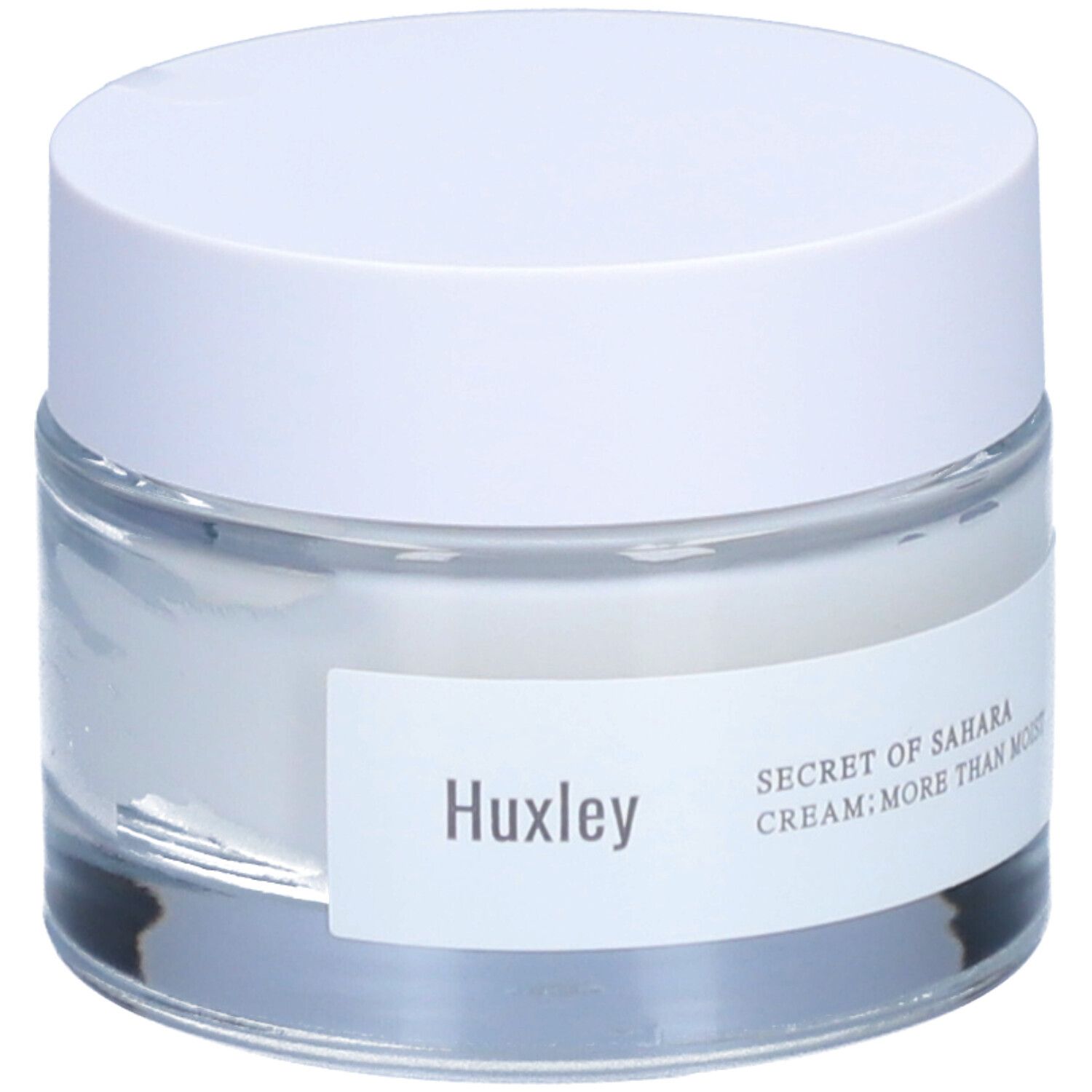 Pot de crème avec couvercle blanc. L'étiquette indique "Huxley" et "SECRET OF SAHARA CREAM; MORE THAN MOIST".