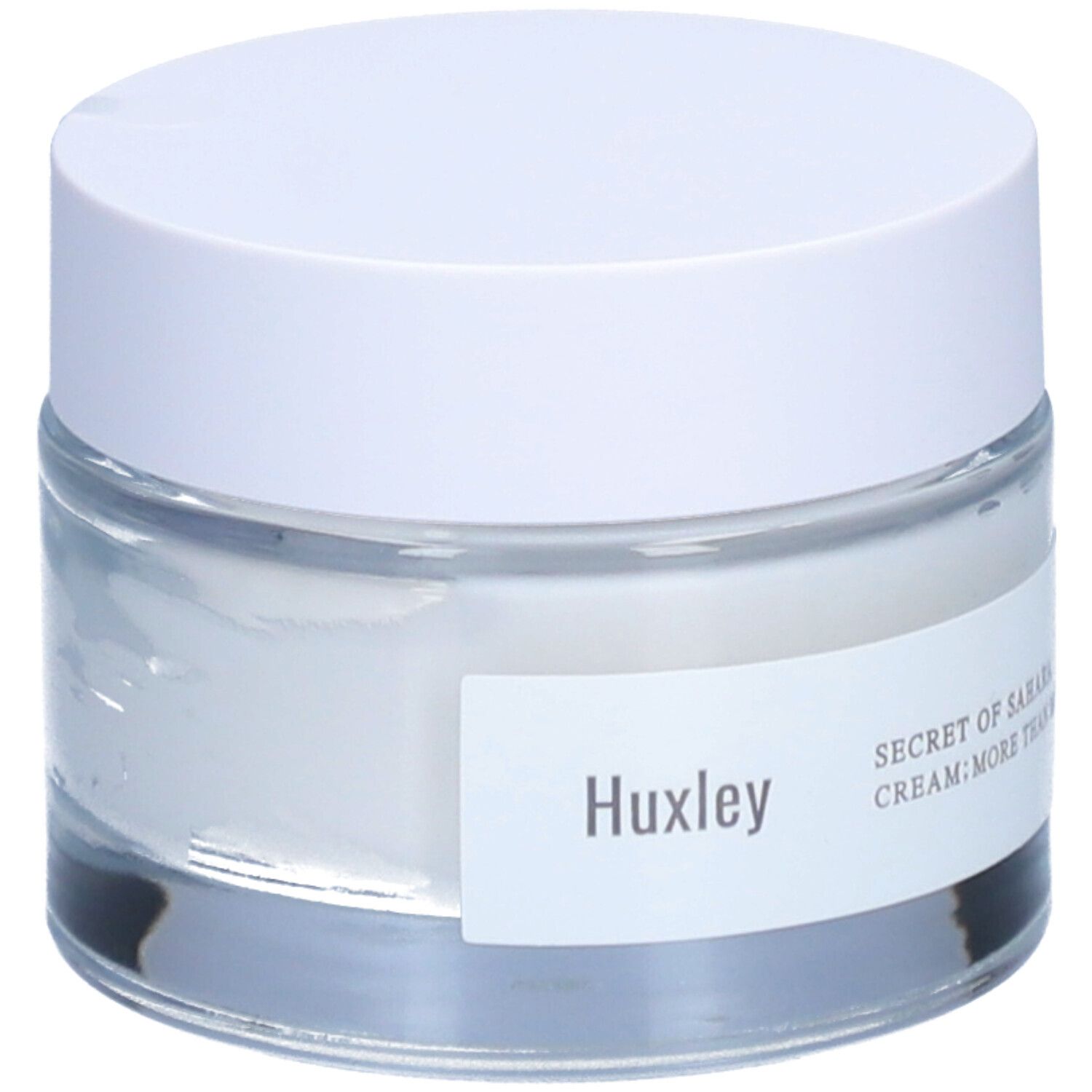 Pot de crème avec couvercle blanc. L'étiquette indique "Huxley" et "SECRET OF SAHARA CREAM; MORE THAN MOIST".