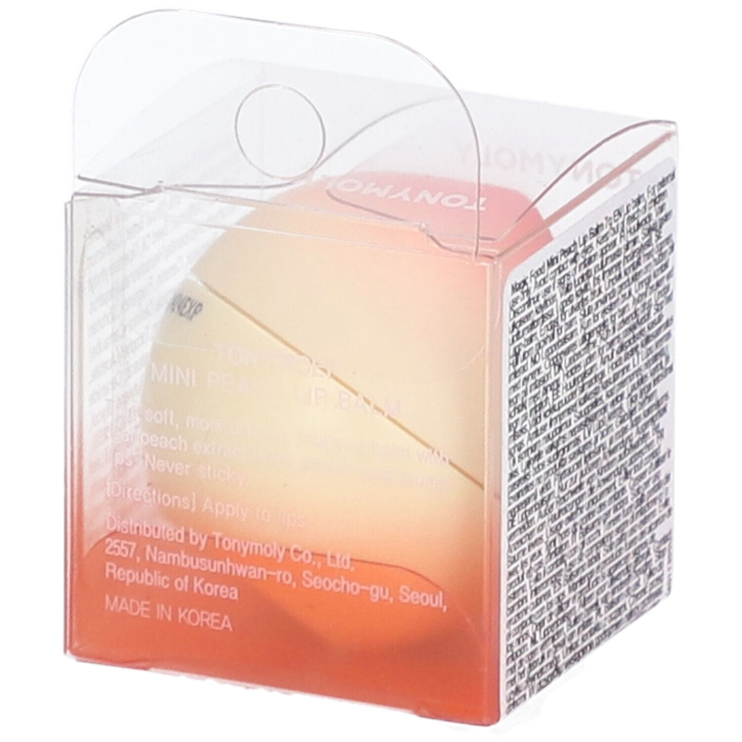 Baume à lèvres en forme de pêche dans un emballage transparent. Inscription : MINI PEACH LIP BALM. Texte sur l'emballage. Fabriqué en Corée.