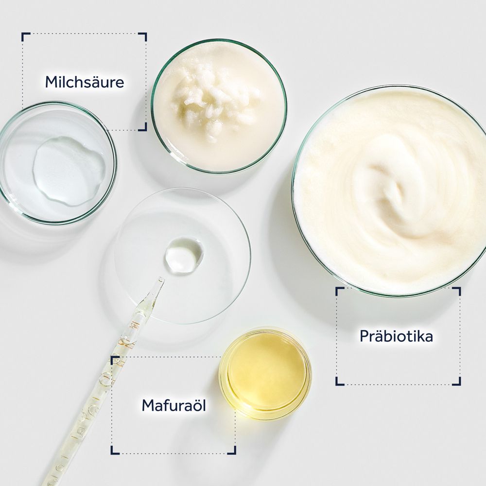 Ingrédients de soin de la peau : acide lactique, huile de Mafura, prébiotiques dans des récipients de laboratoire.