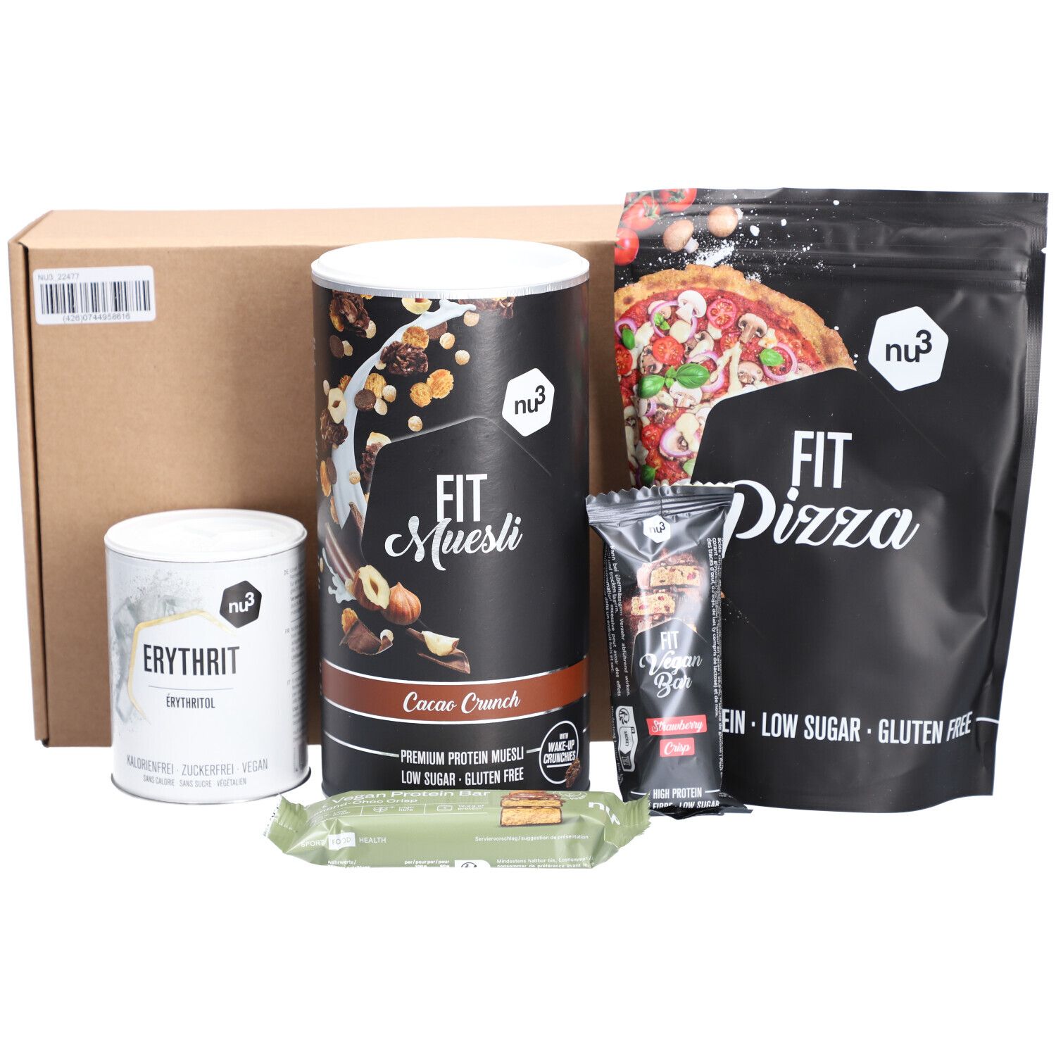 Boîte brune avec divers produits nu3 : Fit Muesli, Erythrit, Fit Pizza, barre protéinée et barre. Tous les produits affichent le logo nu3.