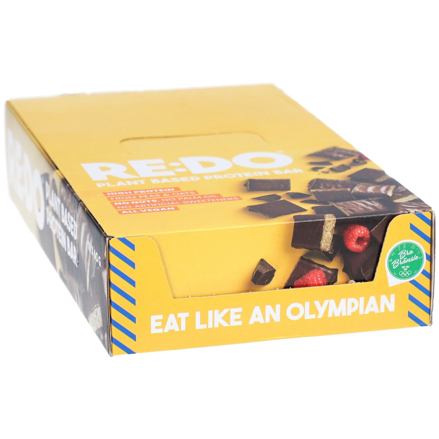 Boîte jaune de barres chocolatées RE:DO. Inscription : Plant Based Protein Bar. Visible : morceaux de barres avec framboises. Inscription : Eat like an Olympian. Vegan.