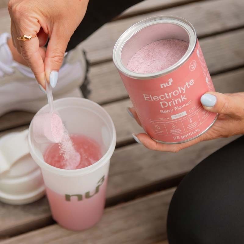 Préparation du nu3 Elektrolyte Drink Berry : poudre versée dans un gobelet.