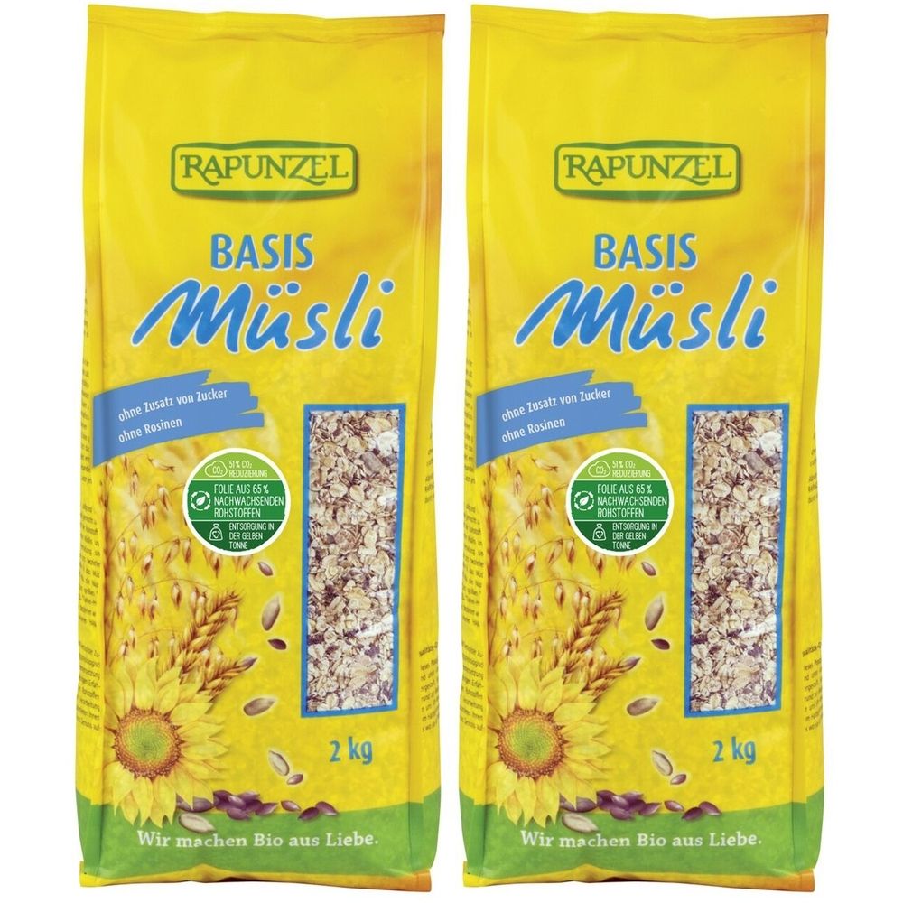Deux paquets jaunes de RAPUNZEL Basis Müsli. Inscriptions : sans sucre ajouté, 2 kg, label bio. Illustration de tournesols et de céréales.