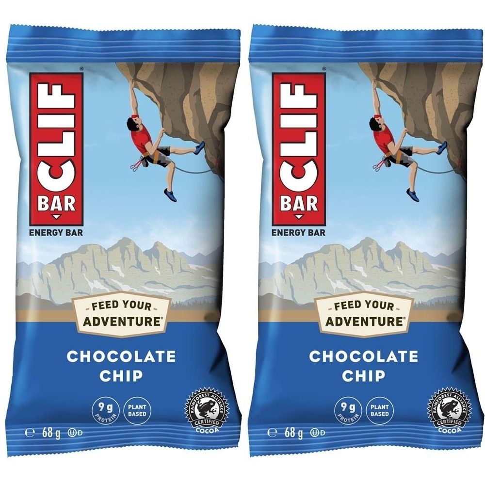 Deux emballages bleus de barres énergétiques CLIF BAR. Inscription : CLIF BAR, pépites de chocolat, 9g de protéines, certification cacao.