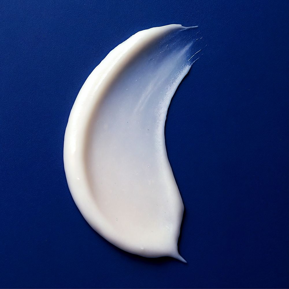 Trace de crème blanche sur fond bleu.