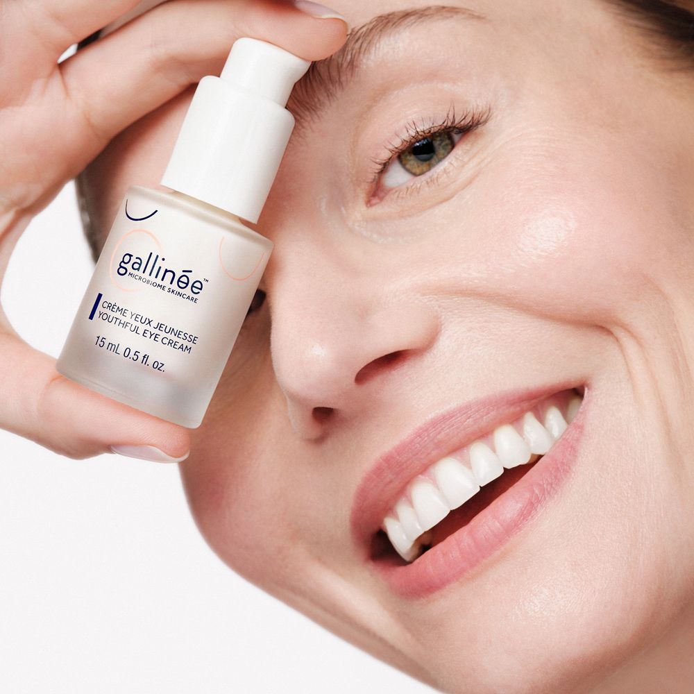 Femme tenant un flacon. Inscription: Gallinée, Crème Yeux Jeunesse, 15 ml 0.5 fl. oz.