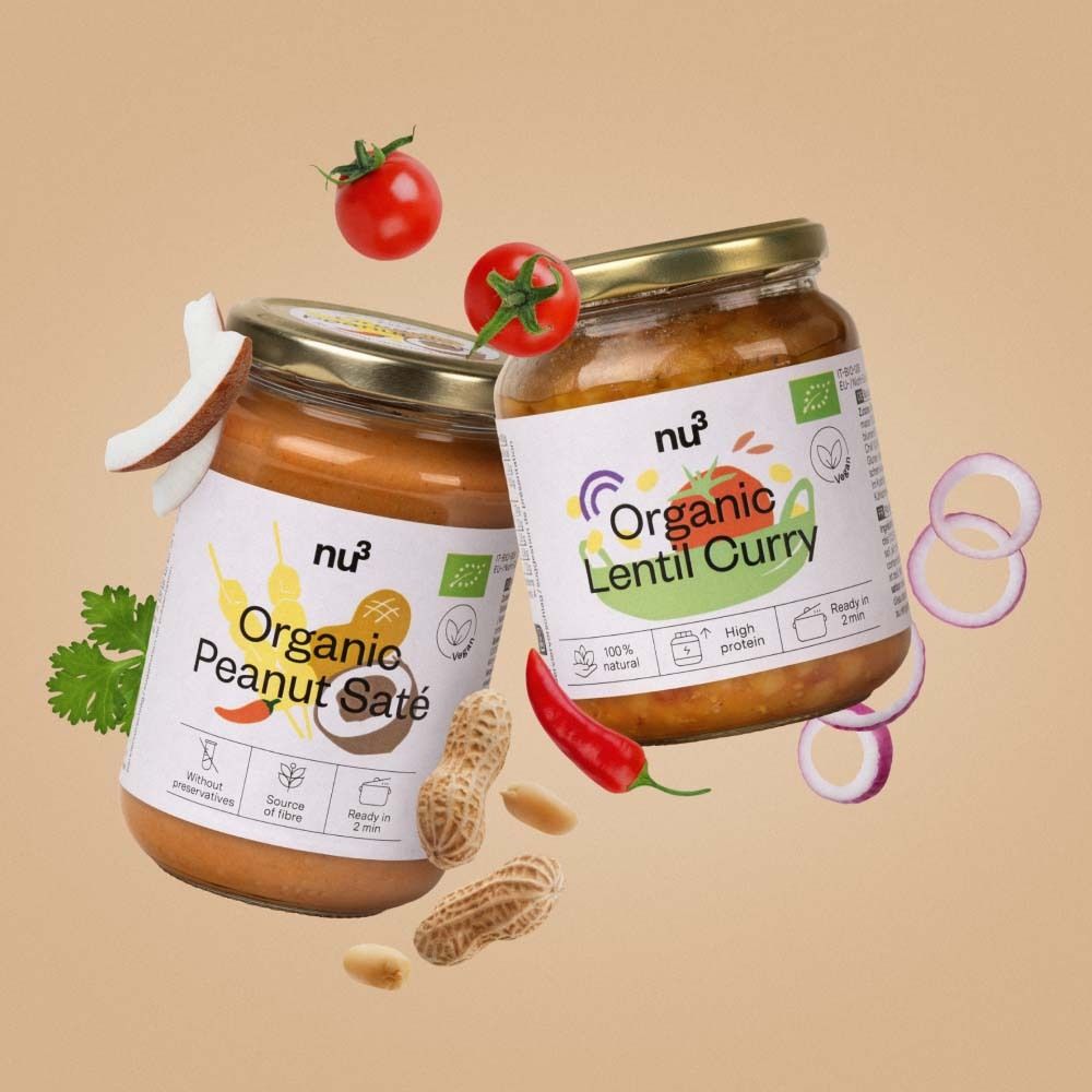 Deux pots de "nu3 Organic Peanut Saté" et "Organic Lentil Curry" avec des ingrédients comme tomates, cacahuètes et noix de coco.