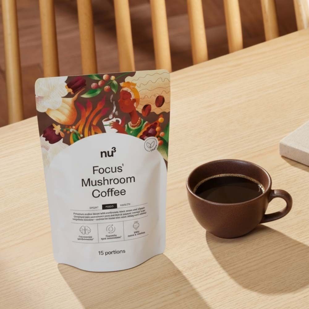 Tasse de café à côté de l'emballage de nu3 Focus Mushroom Coffee. Sur table en bois.