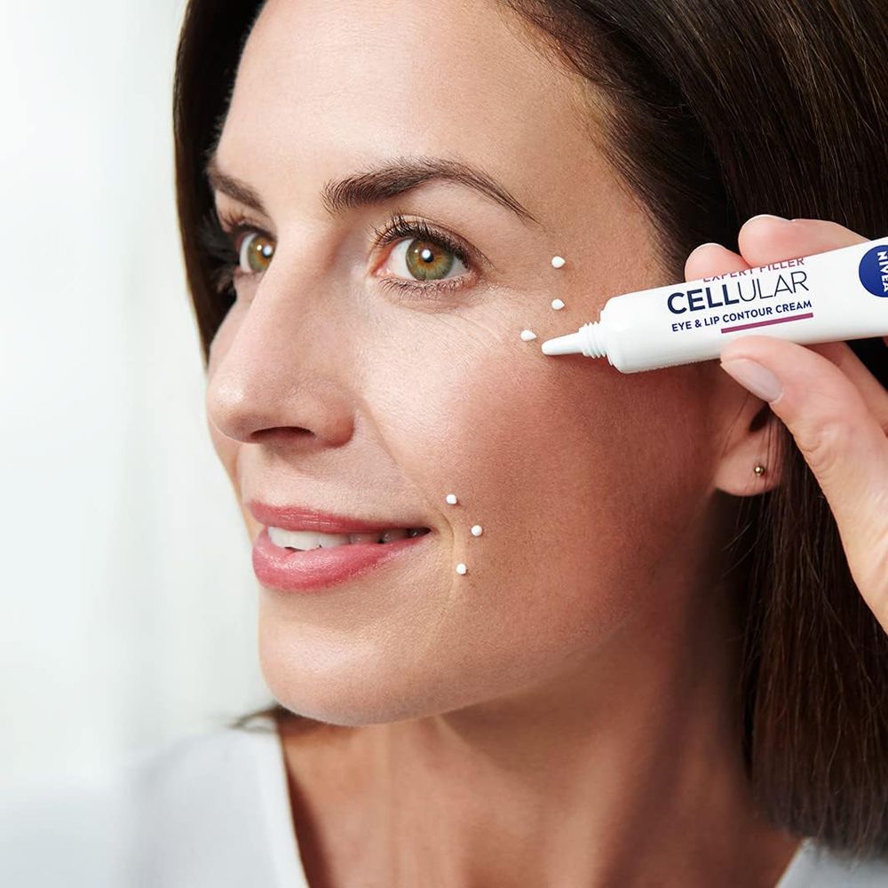 Une femme applique le soin contour yeux et lèvres NIVEA CELLULAR Expert Filler.