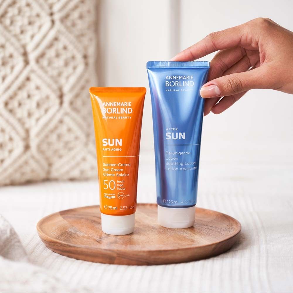 Deux tubes sur un plateau en bois. Un tube orange et un bleu. Main qui saisit le tube bleu.