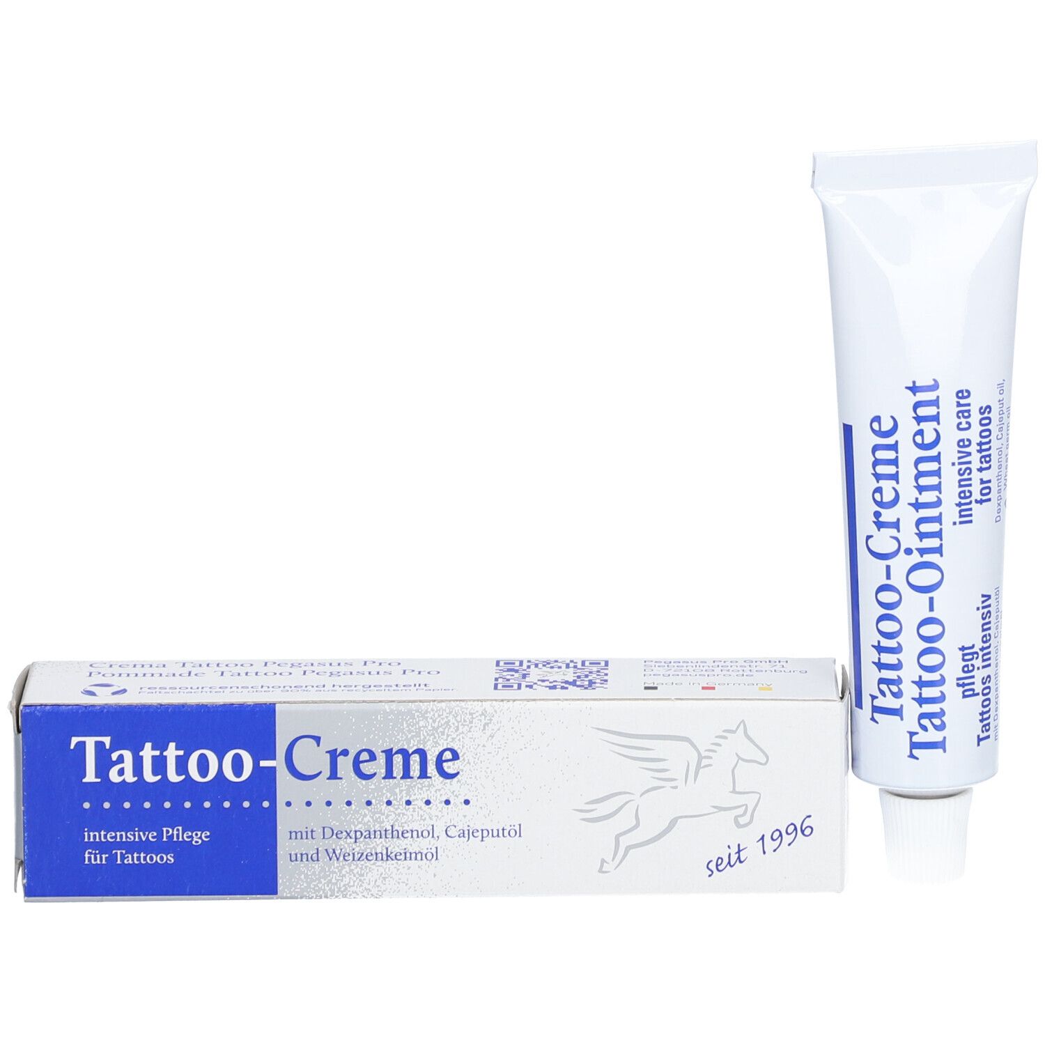 Tube et boîte de Tattoo-Creme. Boîte avec zone bleue et logo. Contient dexpanthénol, huile de cajeput et huile de germe de blé. Depuis 1996.