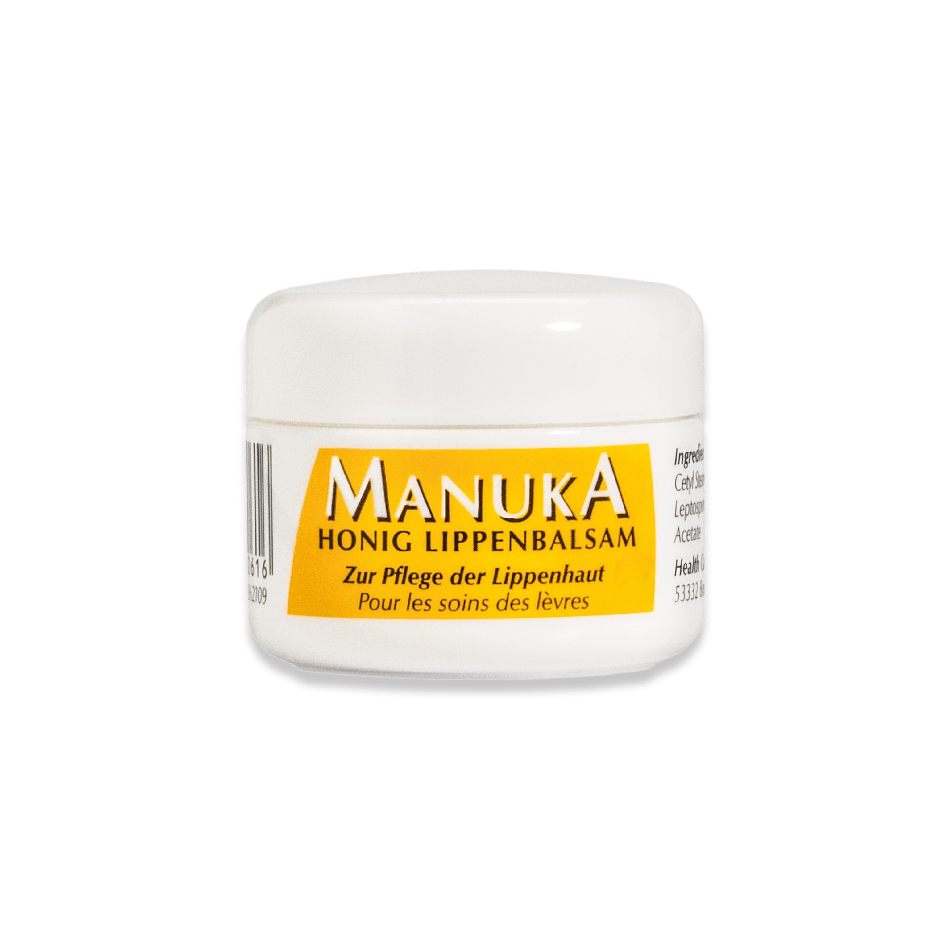 Pot blanc avec étiquette jaune. Inscription: MANUKA Honig Lippenbalsam.