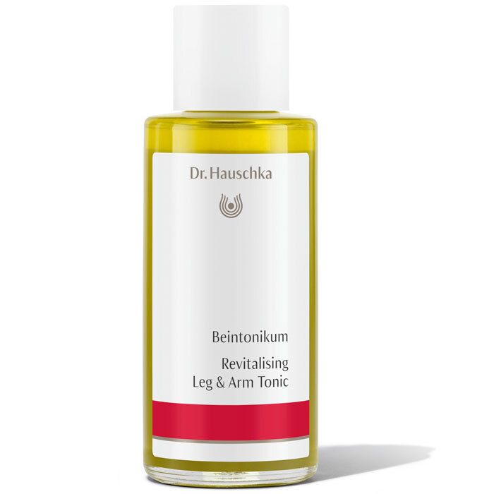 Flacon en verre avec bouchon blanc. Étiquette avec nom du produit et marque Dr. Hauschka. Bande rouge.
