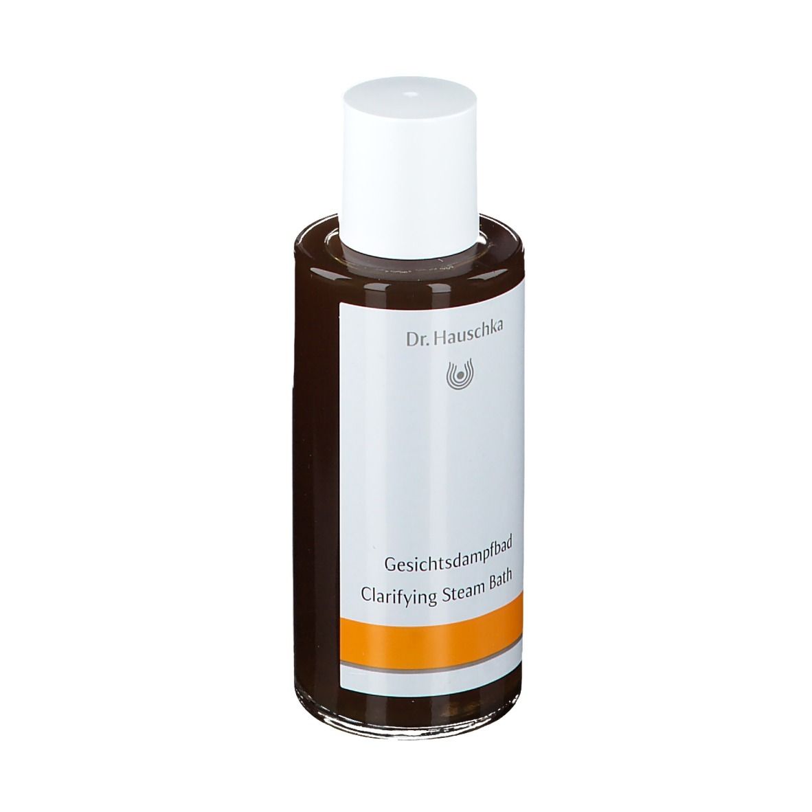 Flacon en verre brun avec bouchon blanc. Étiquette avec nom du produit et marque Dr. Hauschka. Bande orange.