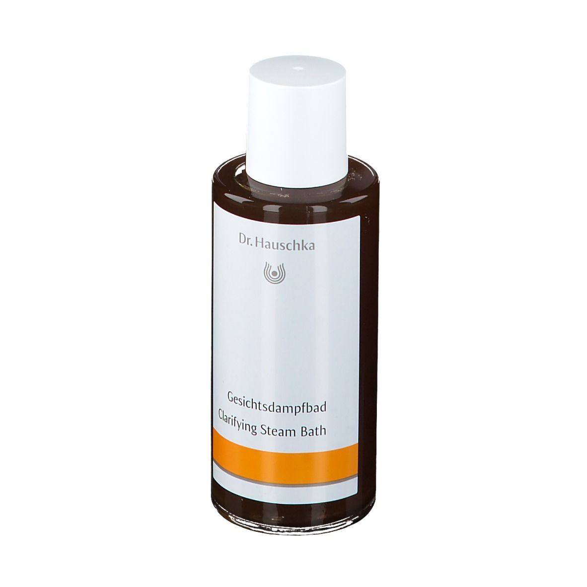 Flacon en verre brun avec bouchon blanc. Étiquette avec nom du produit et marque Dr. Hauschka. Bande orange.