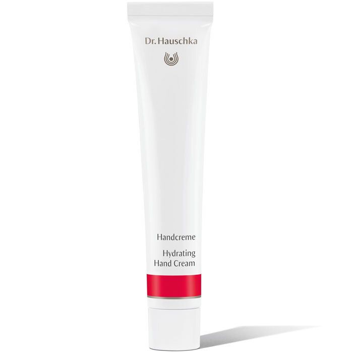 Tube blanche avec bande rouge. Inscription: Dr. Hauschka, Handcreme, Hydrating Hand Cream.