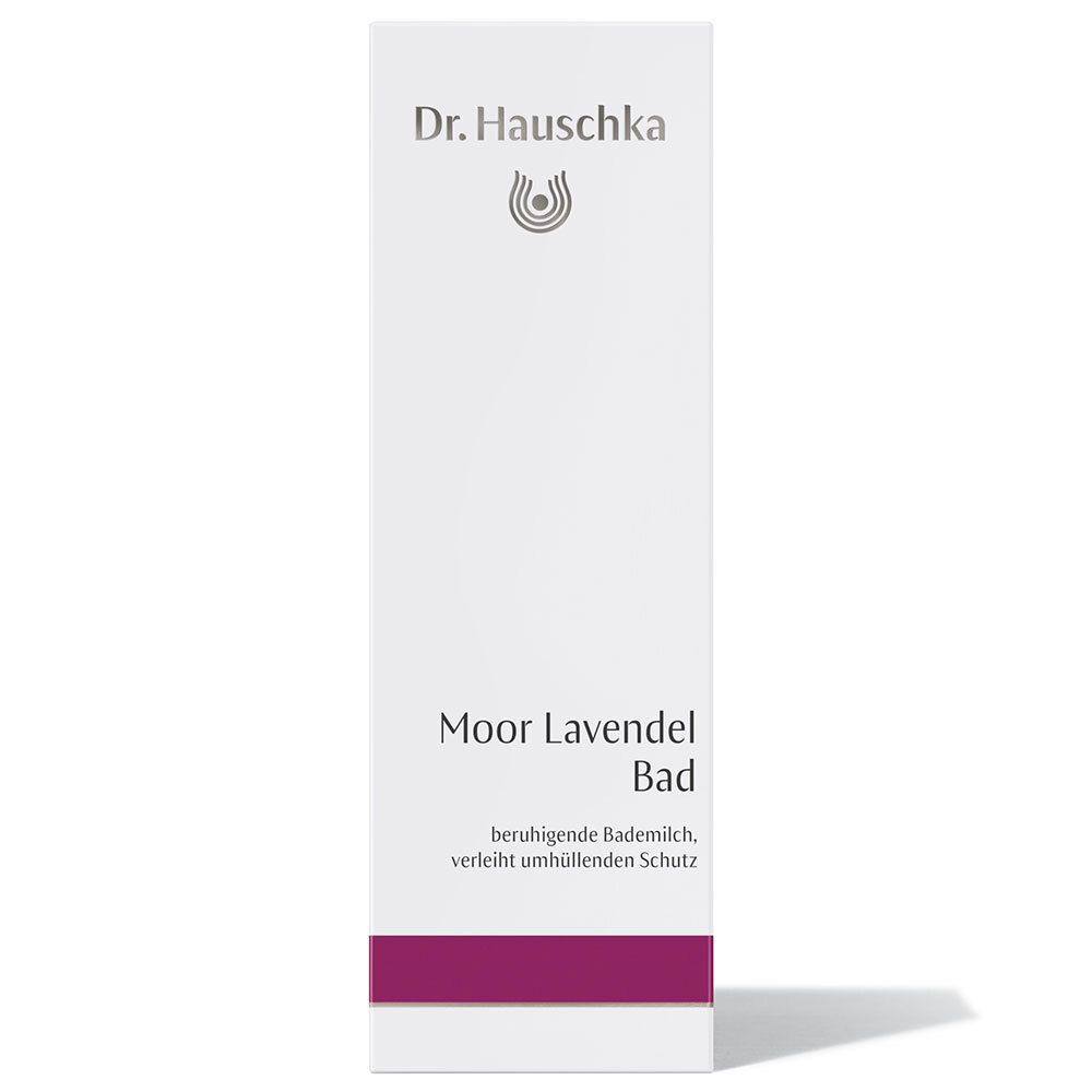 Emballage blanc avec inscription : Dr. Hauschka, Moor Lavendel Bad. Bande rouge en bas. Texte en allemand.