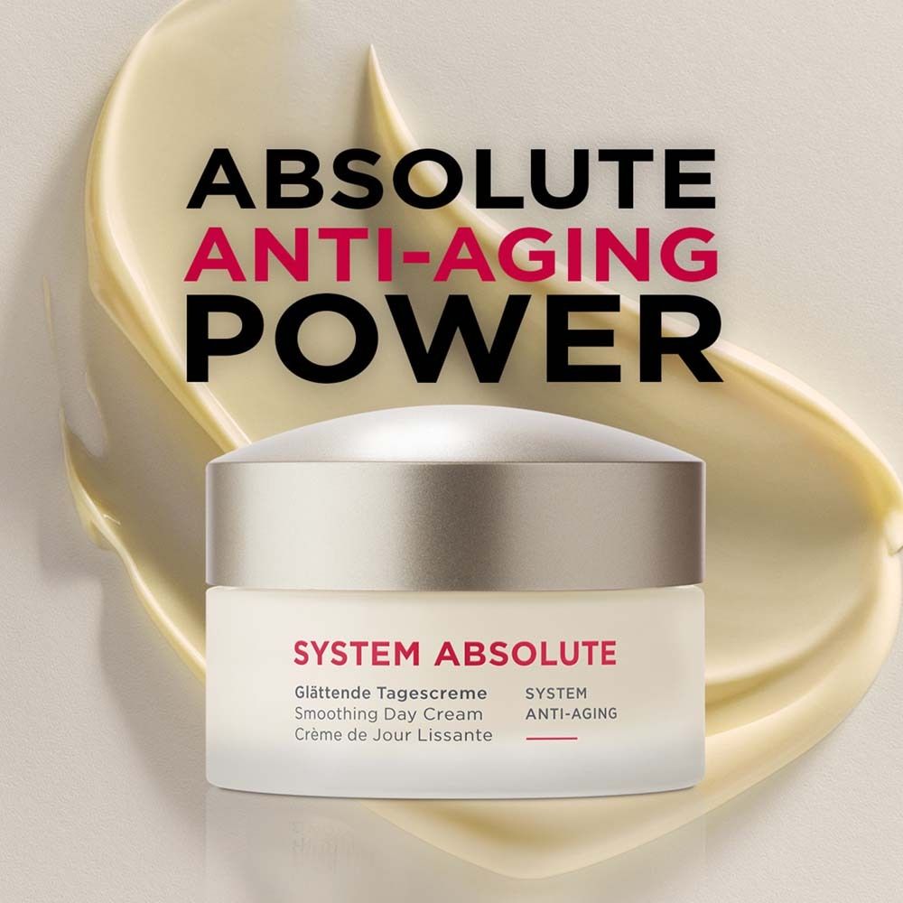 Pot de crème sur fond jaune. Inscription : SYSTEM ABSOLUTE, Crème de Jour Lissante, Smoothing Day Cream, Glättende Tagescreme.