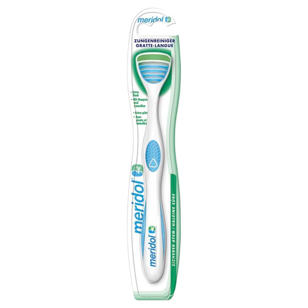 Nettoyeur de langue dans un emballage blister. Manche blanc, accent bleu, zone de nettoyage verte. Marque meridol.
