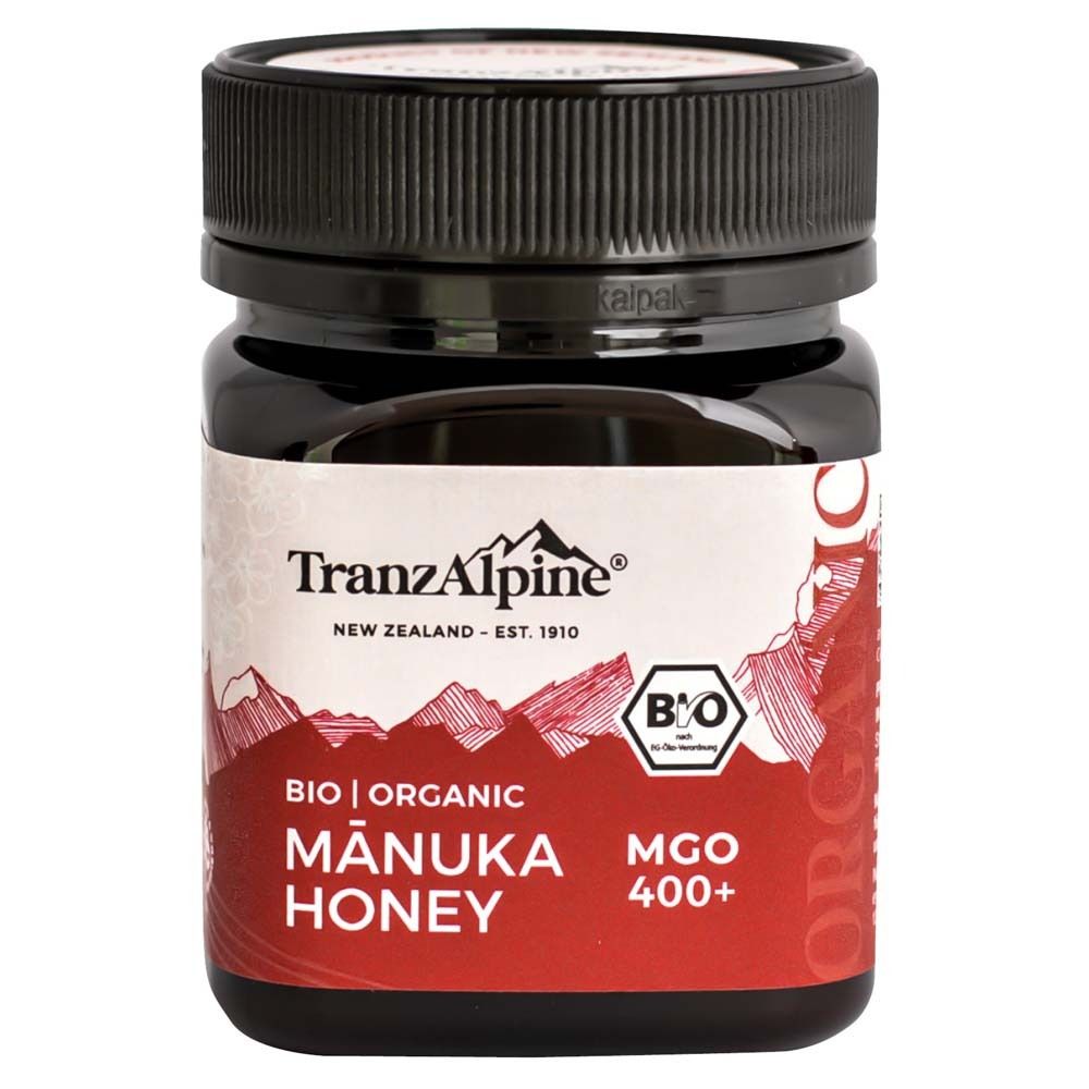 Miel Bio Manuka TranzAlpine, MGO 400+. Pot en verre foncé avec étiquette rouge et motif de montagne.